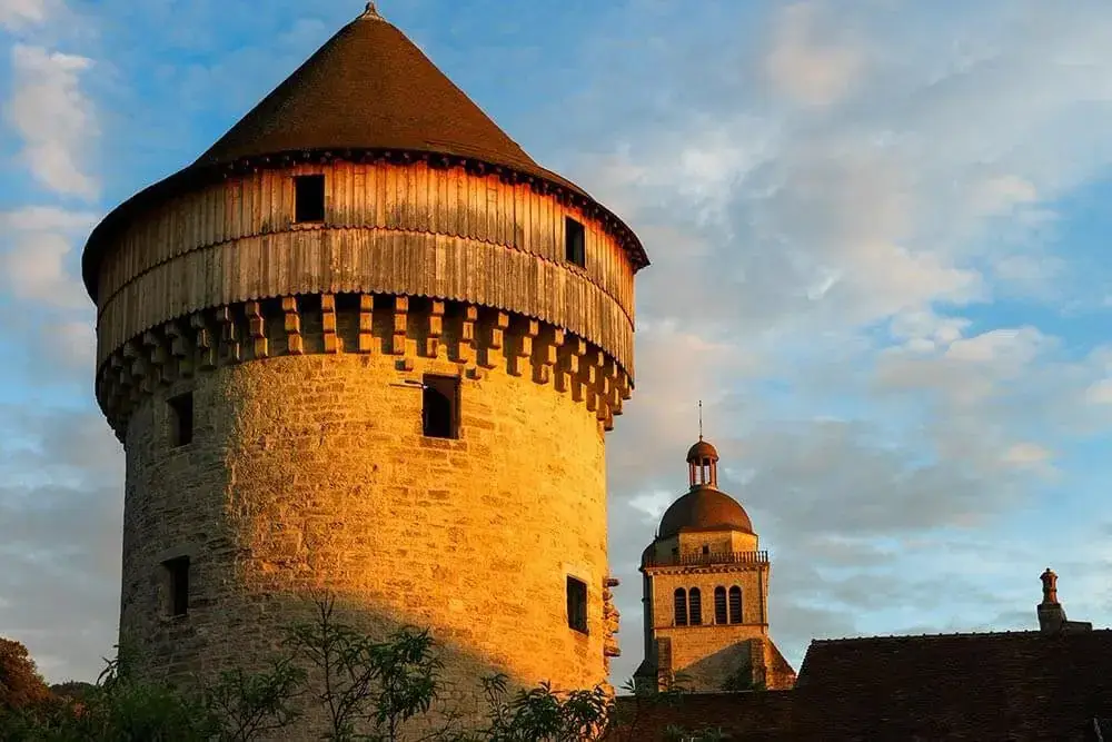 Tour de la Sergenterie et clocher doré de Poligny au soleil couchant